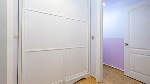 A hallway with a white door on the right and a white closet with a sliding door on the left. - Hotel Sufi (Istanbul)