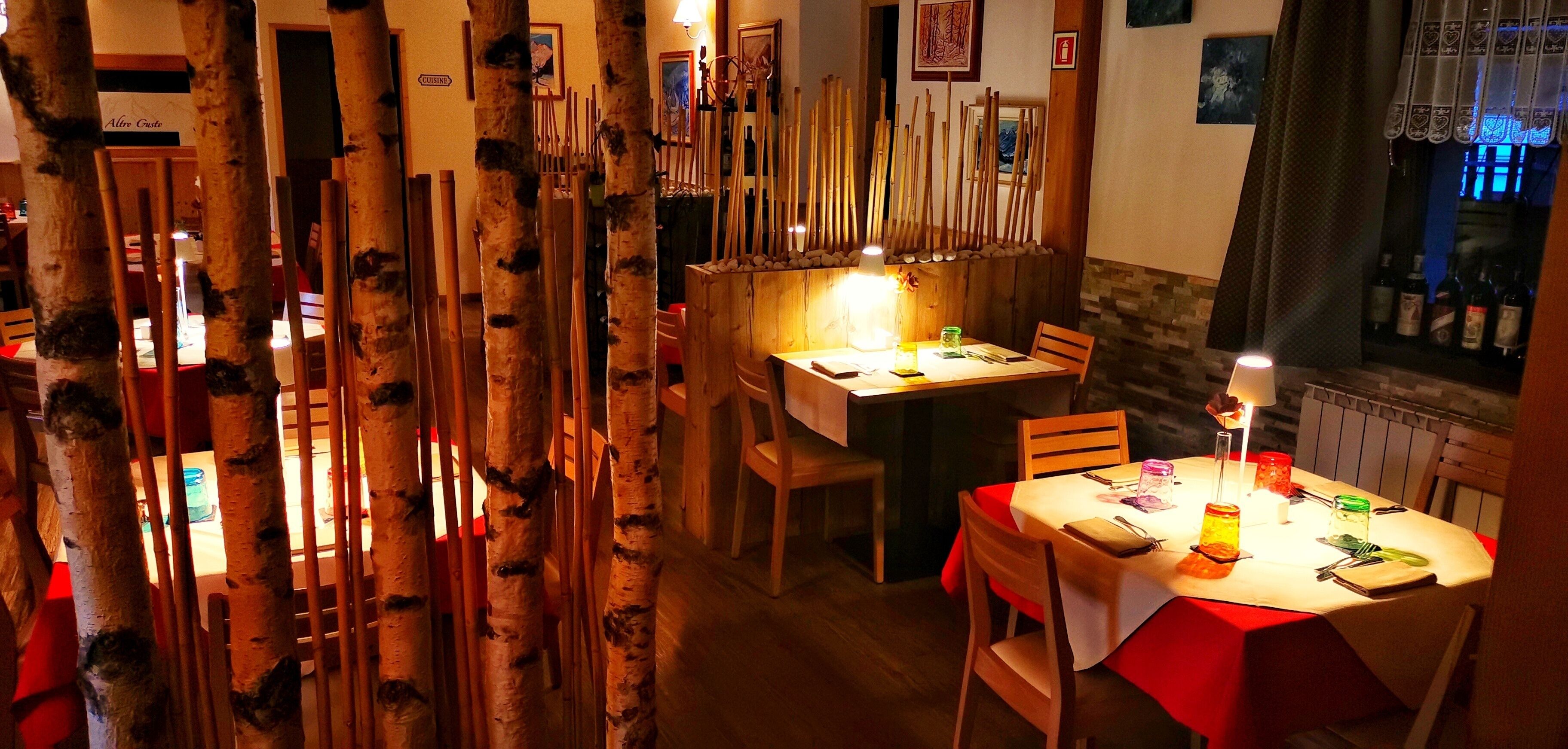 A restaurant with wooden decor, a table set for two, and a view of bottles in the background.