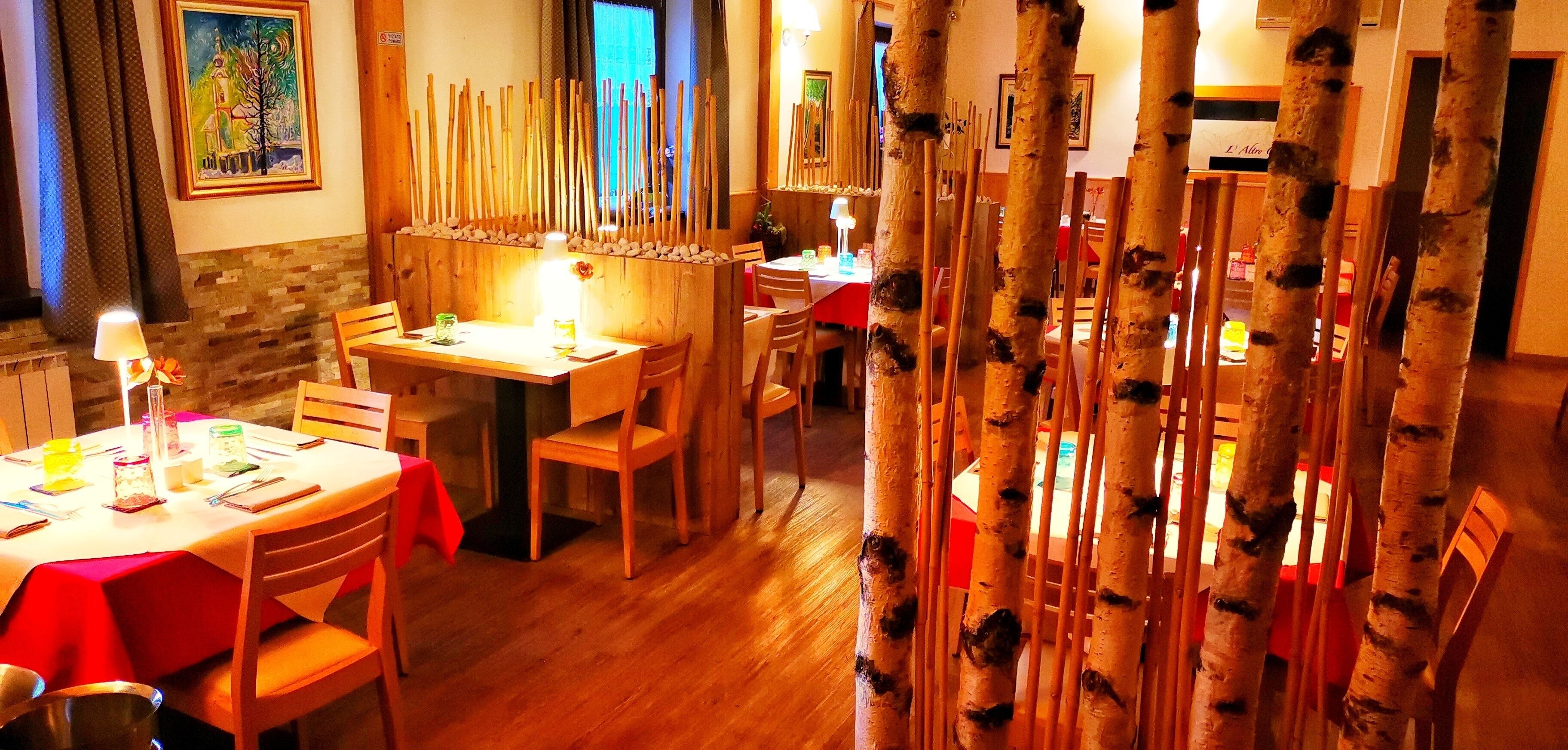 Un área de comedor con sillas y mesas de madera, un panel decorativo de madera y un cuadro en la pared.