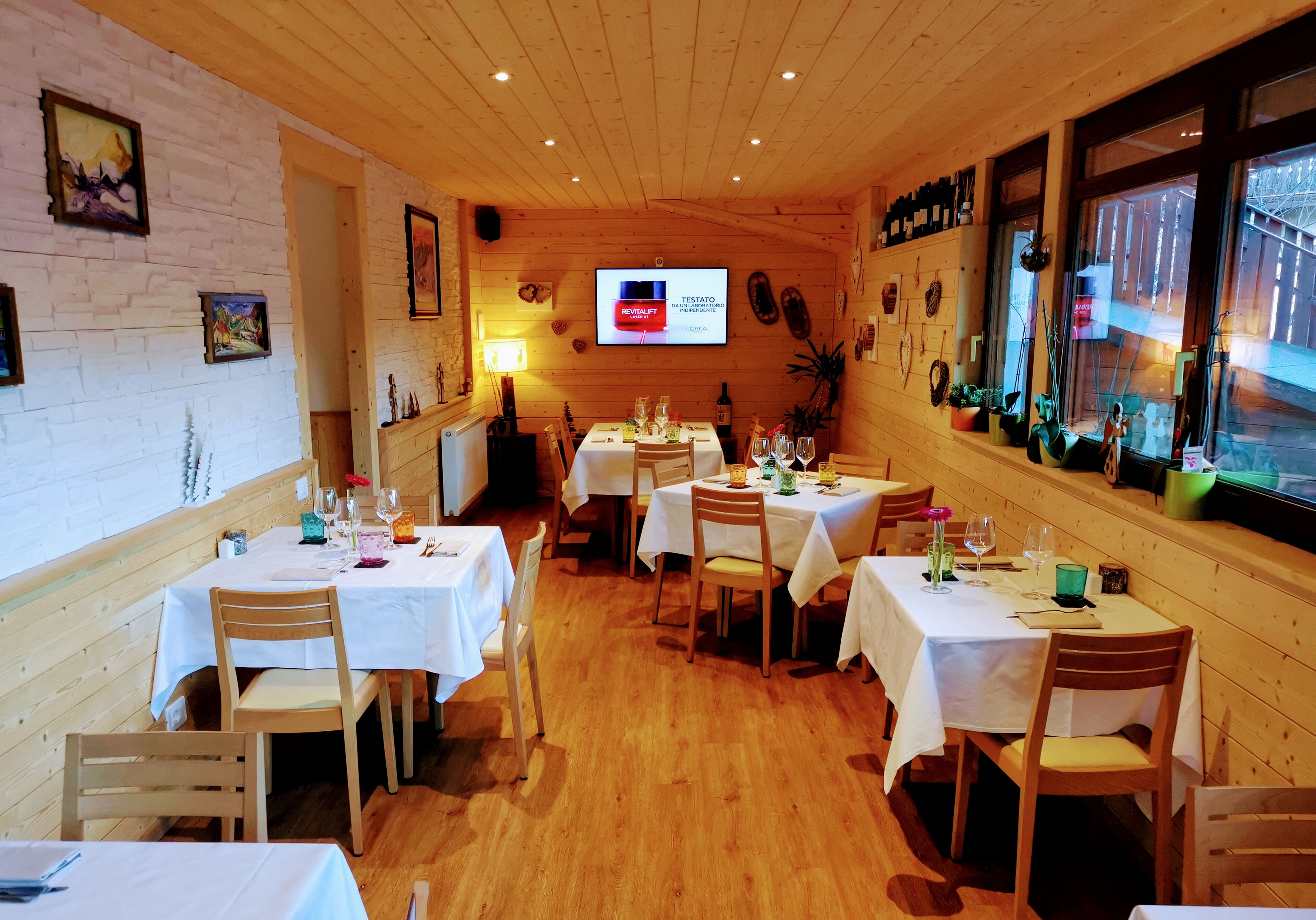 Un restaurante acogedor con paredes de madera y mesas blancas.