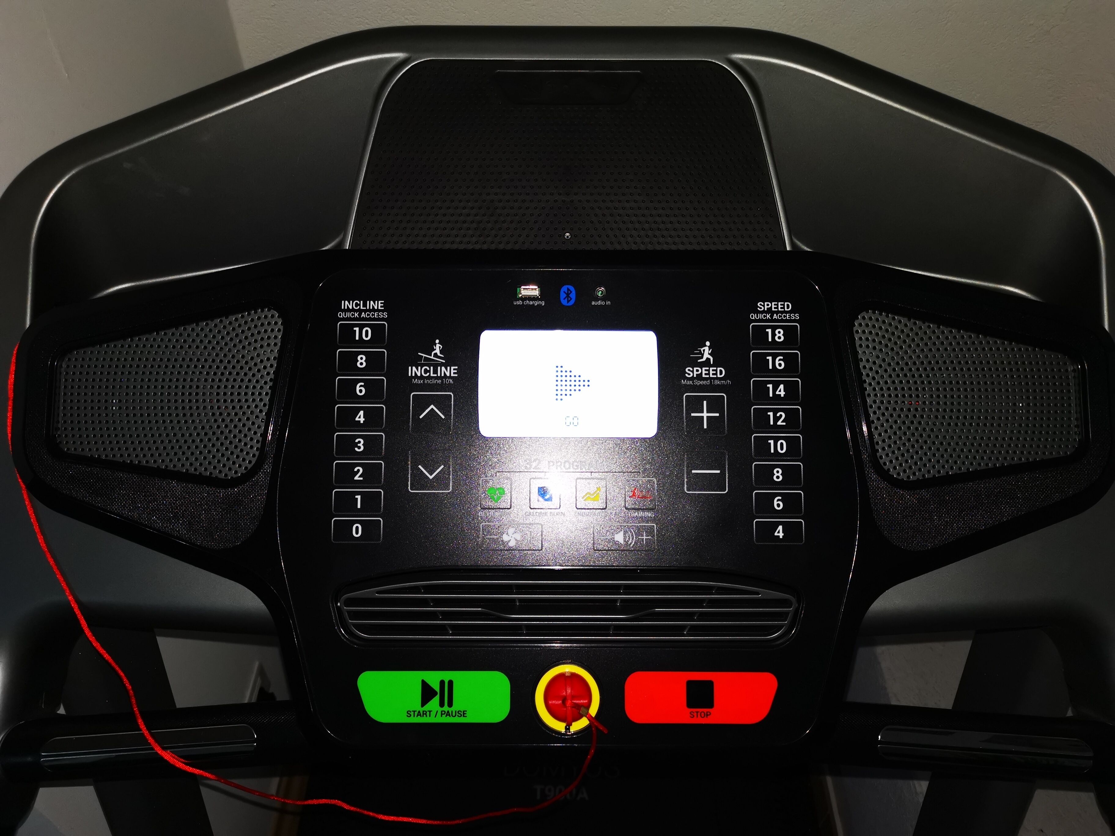 A treadmill control panel with incline and speed settings, a display screen, and start/pause buttons.