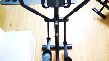 Uma máquina de exercícios com visor digital, painel de controle e pedais.