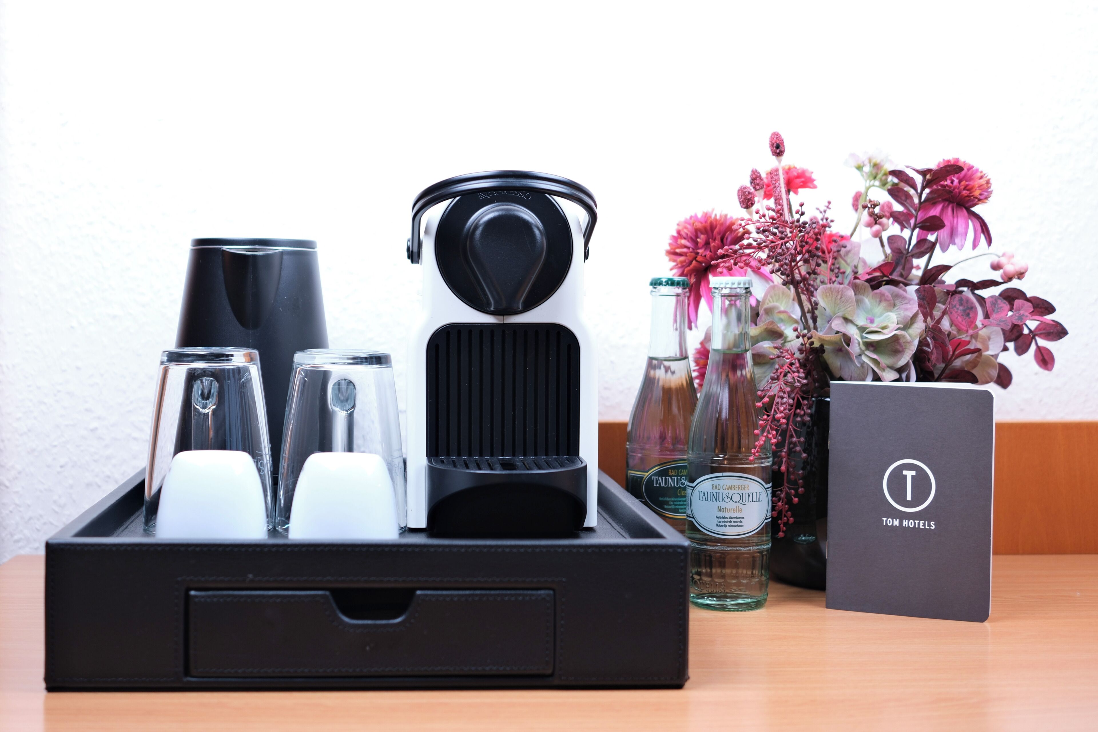 Un plateau avec une cafetière, des verres et une bouteille de tequila Baedeker.