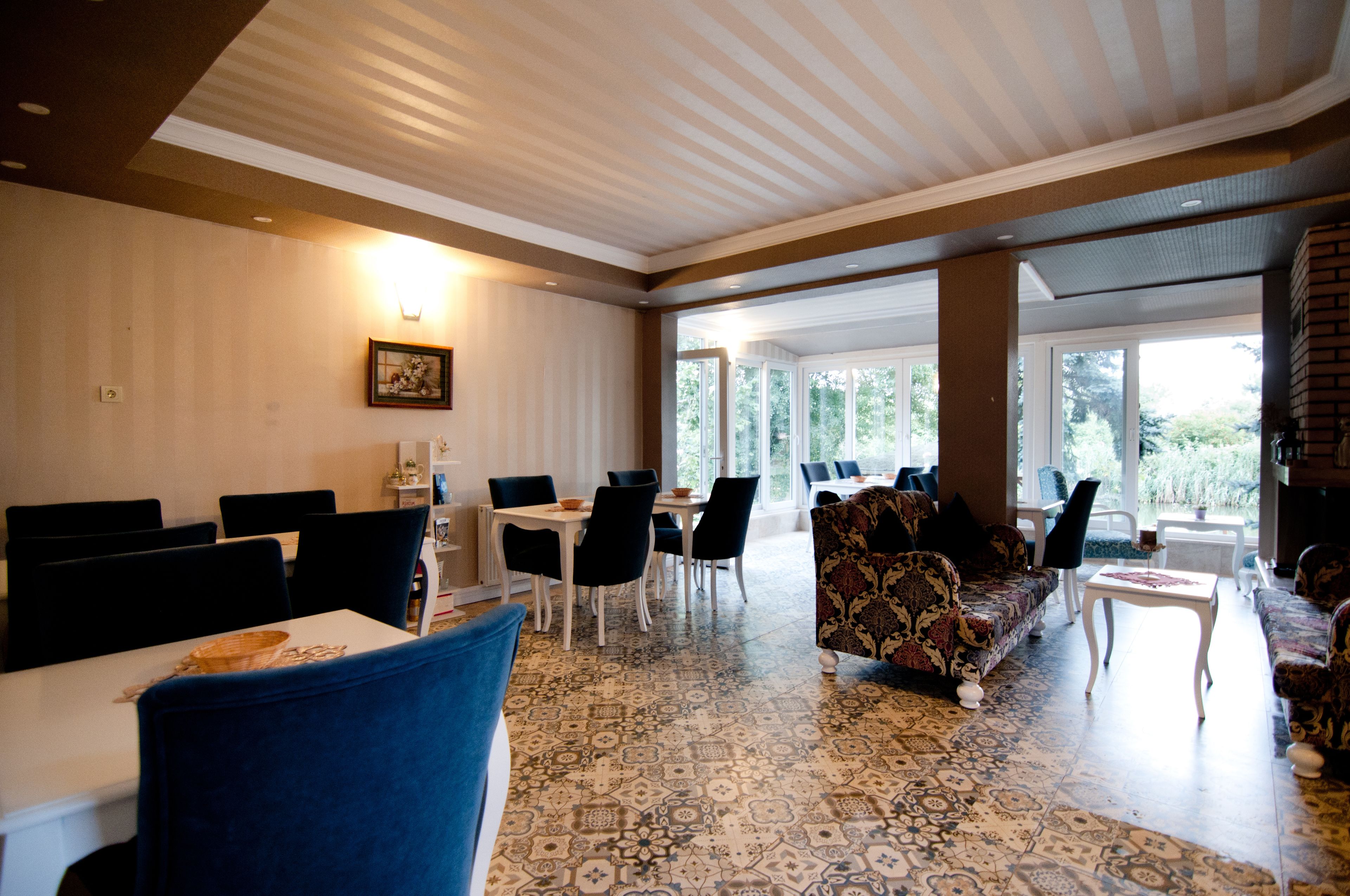 A spacious indoor area with a patterned floor, a sofa, and several tables and chairs.