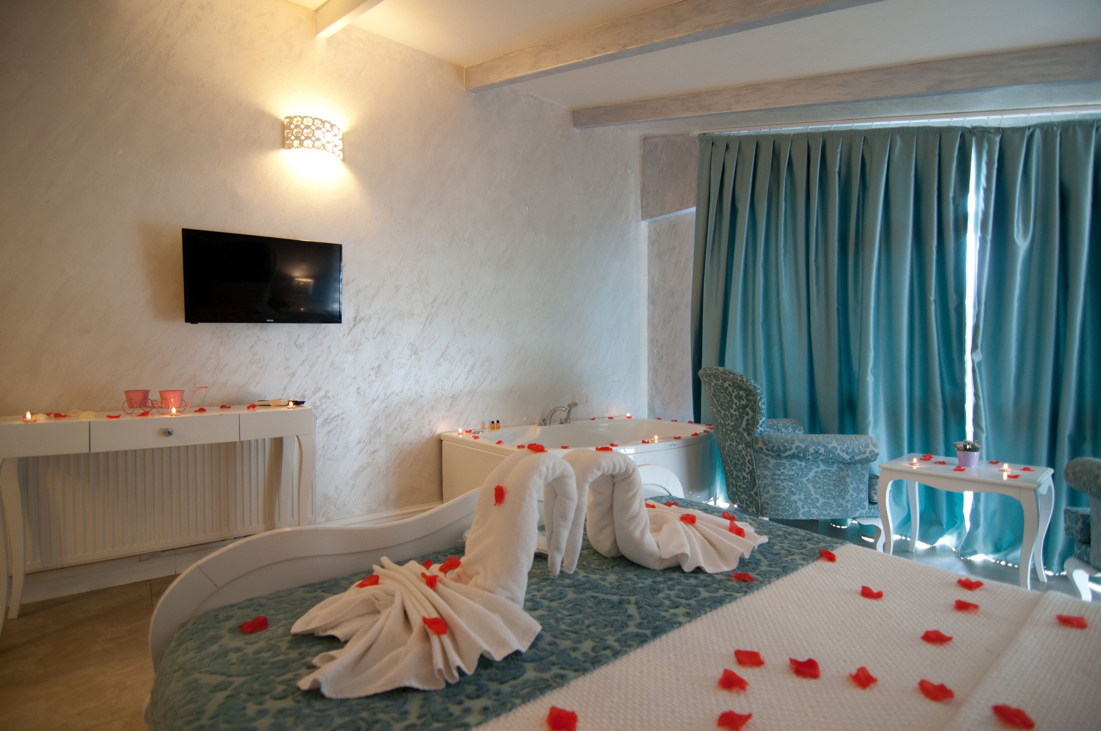 Une chambre d’hôtel comprenant un lit, un coin salon, une télévision et une salle de bain.