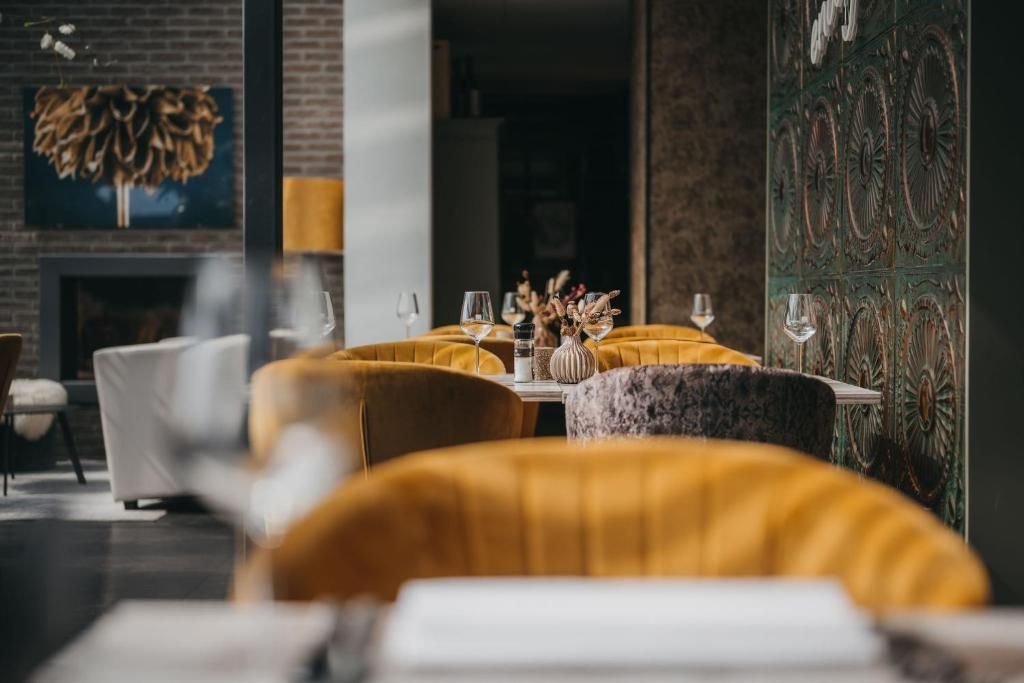 Interior de un restaurante con una mesa para dos, rodeada de sillas tapizadas en amarillo.