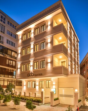 A multi-story hotel with a modern facade, balconies, and illuminated signage. - Ada Suites Nisantasi (Istanbul)