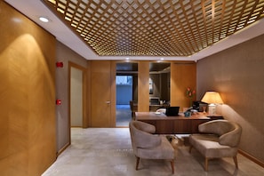 A hotel lobby with a reception desk, two armchairs, a lamp, and a ceiling with a wooden lattice design. - Ada Suites Nisantasi (Istanbul)