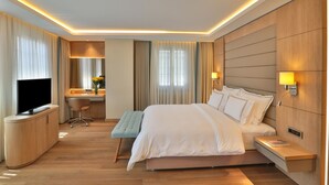 A hotel room with a bed, bedside table, TV, desk, chair, and curtains. - Ada Suites Nisantasi (Istanbul)