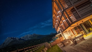 Un edificio moderno con fachada de madera y una terraza con asientos al aire libre.