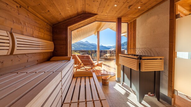 Una sauna de madera con bancos y una mesa de madera.
