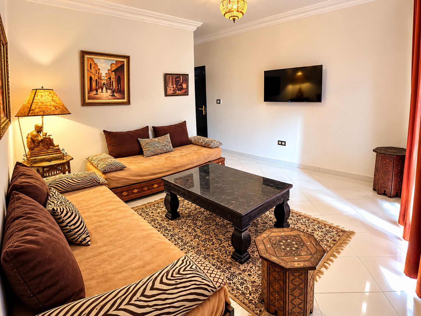 Un salon comprenant un canapé, une table basse, un téléviseur et des objets de décoration.