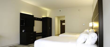 Une chambre d’hôtel avec un grand lit, une armoire, un bureau et un miroir.