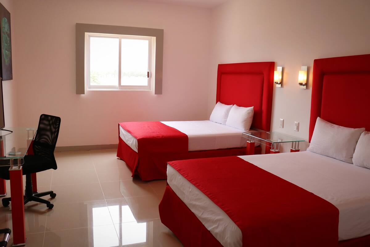 Una habitación de hotel con dos camas, un escritorio y una silla.
