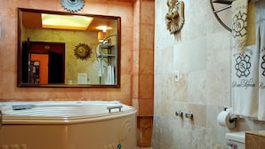 A bathroom with a large bathtub, a toilet, a shower area, and a mirror. - Hotel Real Azteca (Mexico City)