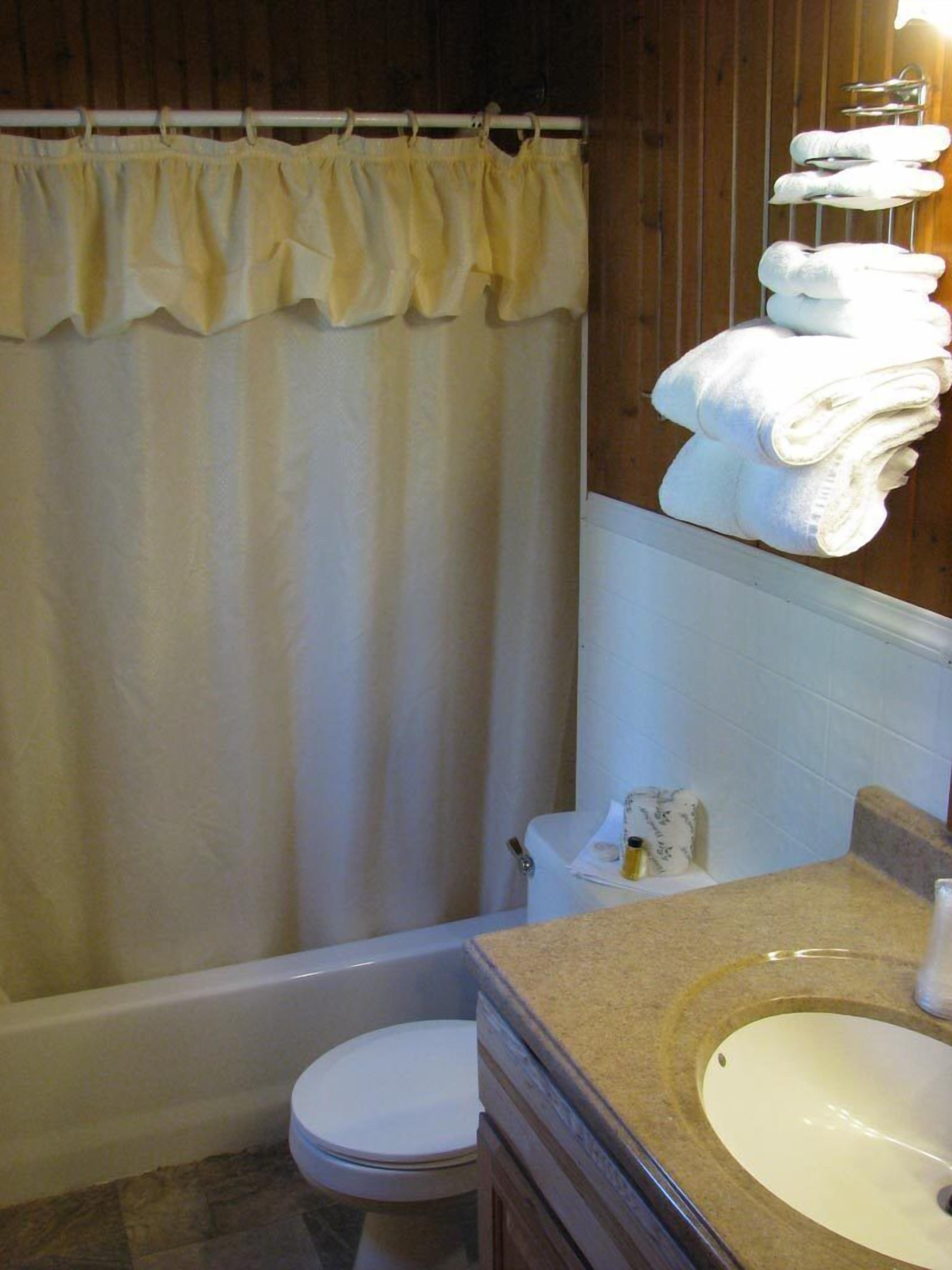 A bathroom with a bathtub, toilet, and sink.