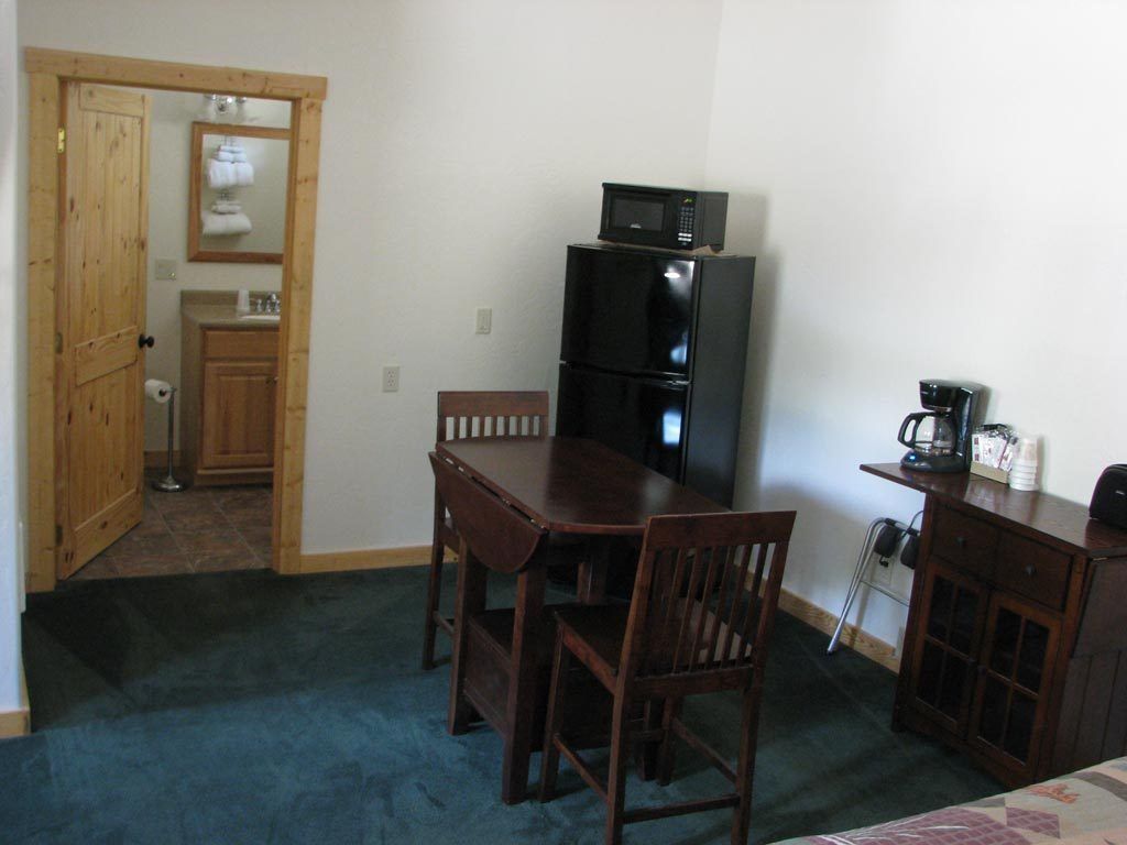 A compact kitchen with a refrigerator, microwave, and coffee maker.