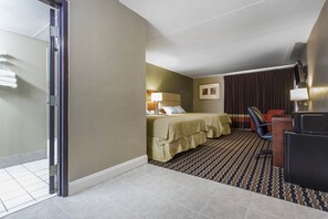 A hotel room with a bed, a desk, a chair, a lamp, and a window with curtains. - Super 8 by Wyndham Battleboro/Rocky Mount (Battleboro)