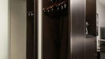 Un vestidor amplio con una puerta espejada, un zapatero y un escalón que lleva a un nivel inferior.