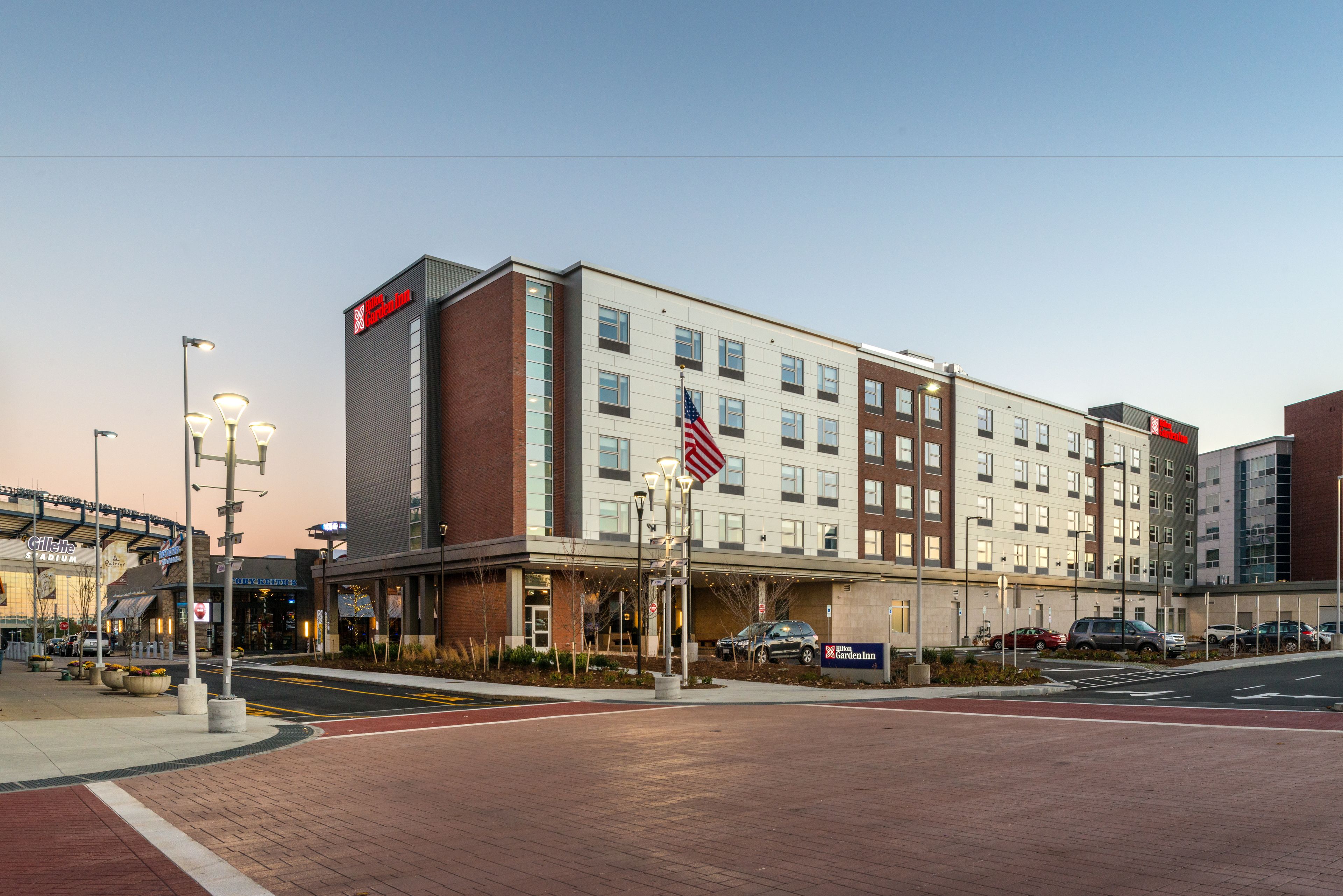 A hotel with a brick facade, multiple windows, and an American flag.