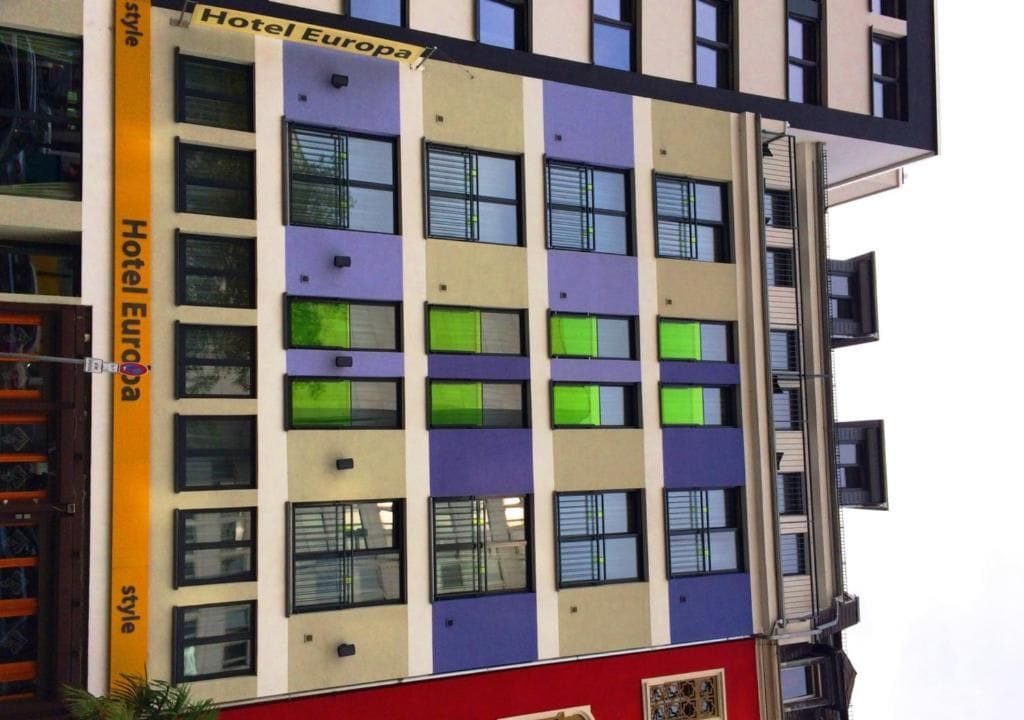 A multi-story hotel building with a modern facade, featuring a mix of window styles and colors.