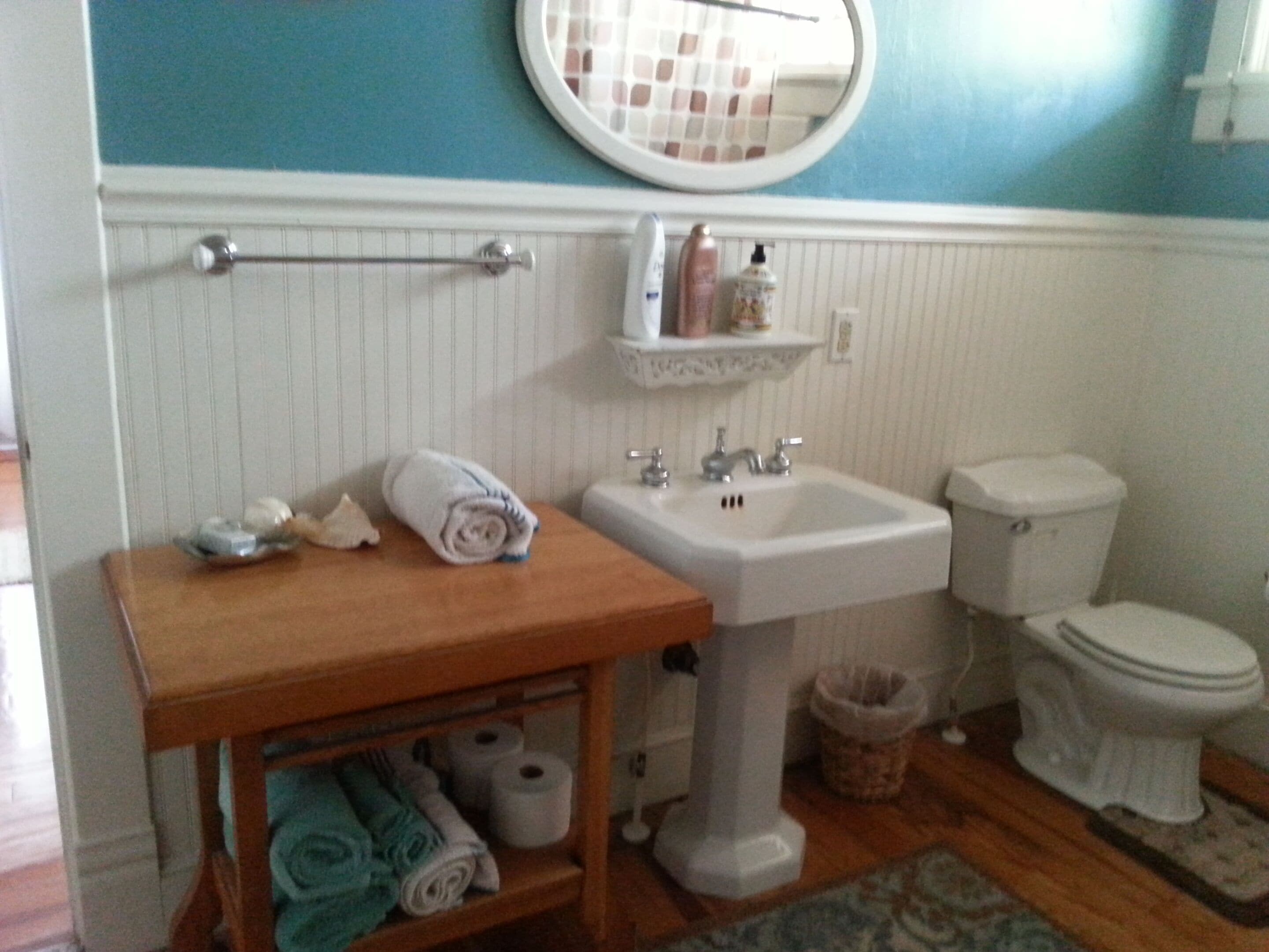 Un baño con lavabo, inodoro y toallero.