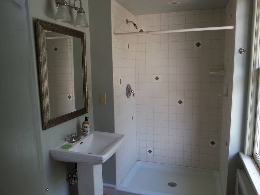 Ein Badezimmer mit Waschbecken, Spiegel und Dusche.