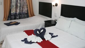 A hotel room with two beds, a red runner, and a black nightstand with a lamp. - Hotel Millenium (Rio Segundo)