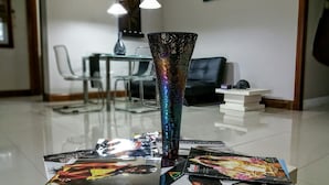Un espacio de oficina moderno con una mesa de vidrio, un jarrón decorativo y revistas esparcidas.