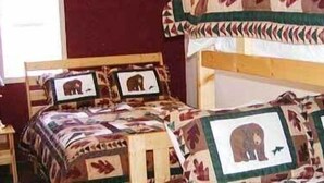 Habitación con una cama, colcha estampada de animales y fotografías enmarcadas.