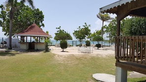 A beachside patio with a gazebo, outdoor seating, and a view of the sea. - Ocho Rios Villa at Coolshade (St. Ann's Bay)