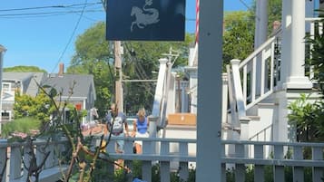 A sign for 'The Martin' pub with a horse emblem, surrounded by a white fence and hydrangea flowers.