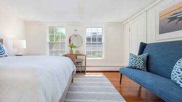 Un dormitorio con cama, escritorio, silla, sofá y ventana.