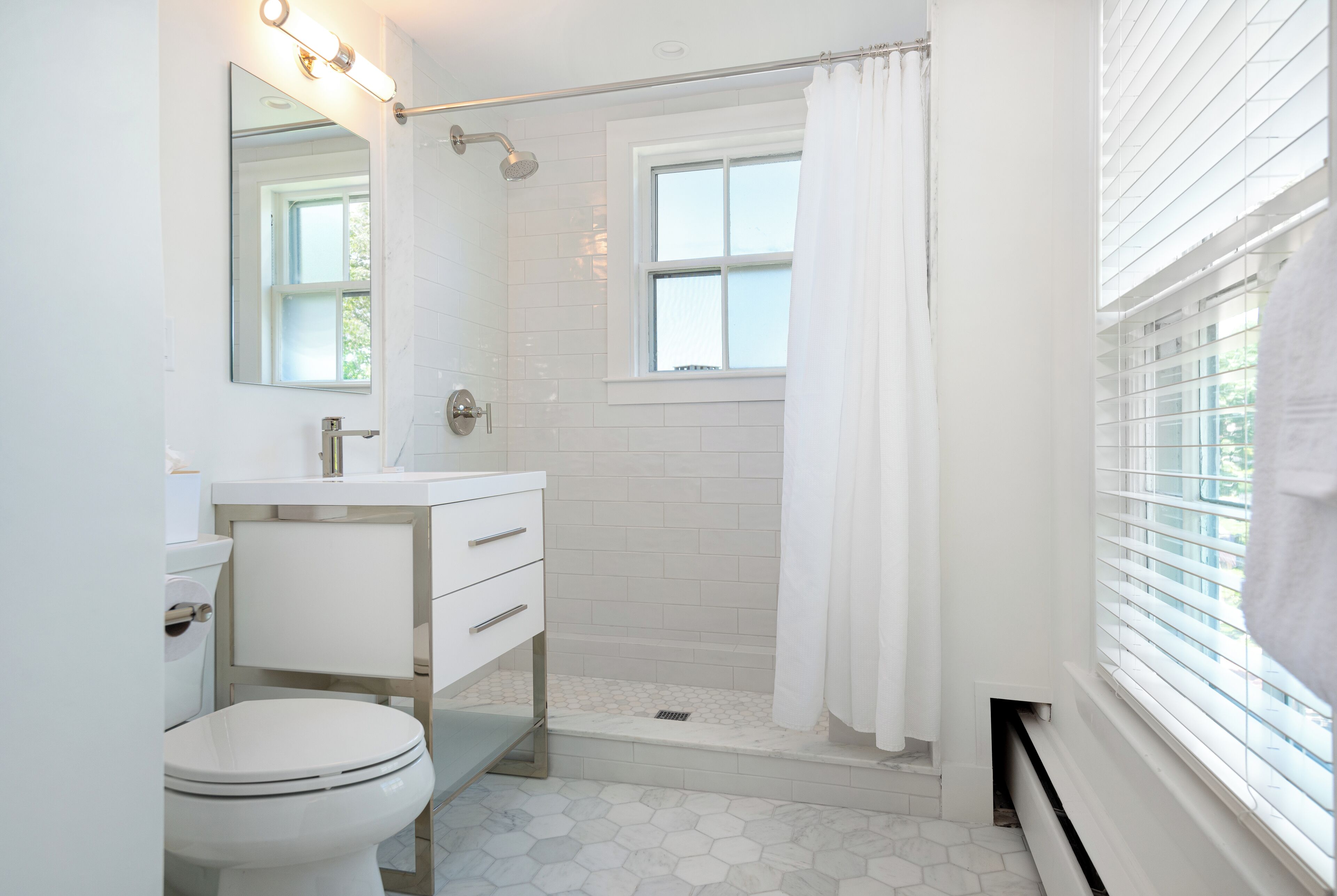 A modern bathroom with a toilet, sink, and shower.