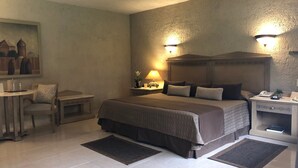 Een hotelkamer met een bed, nachtkastjes, een bureau en een stoel.