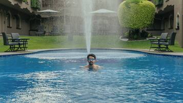 Un homme dans une piscine avec une fontaine.