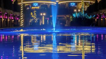 Una piscina al aire libre, sombrillas, sillones reclinables de piscina