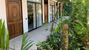 A modern building with wooden doors and large windows, surrounded by lush greenery. - Hotel Manuel Antonio Park (Quepos)