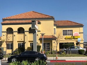 A hotel with a yellow facade, a red-tiled roof, and a sign that reads 'GALI INN'. - Cali Inn (Carson)