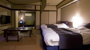 Habitación de hotel con dos camas, televisor, escritorio y silla.