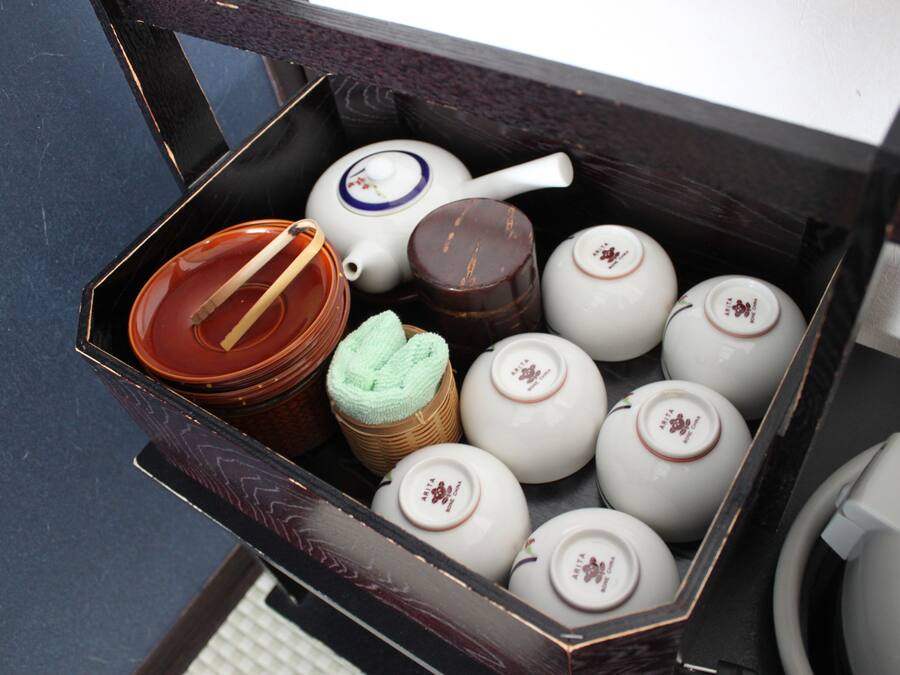 A box containing various tea sets and a teapot.