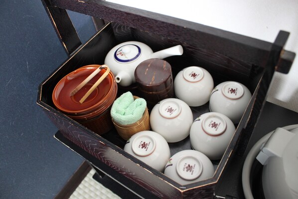 A box containing various tea sets and a teapot.