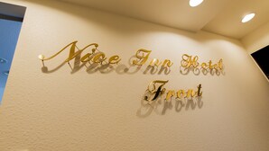 A wall with the text "Nice Inn Hotel Front" in gold lettering. - Nice Inn Hotel Ichikawa Tokyo Bay (Ichikawa)