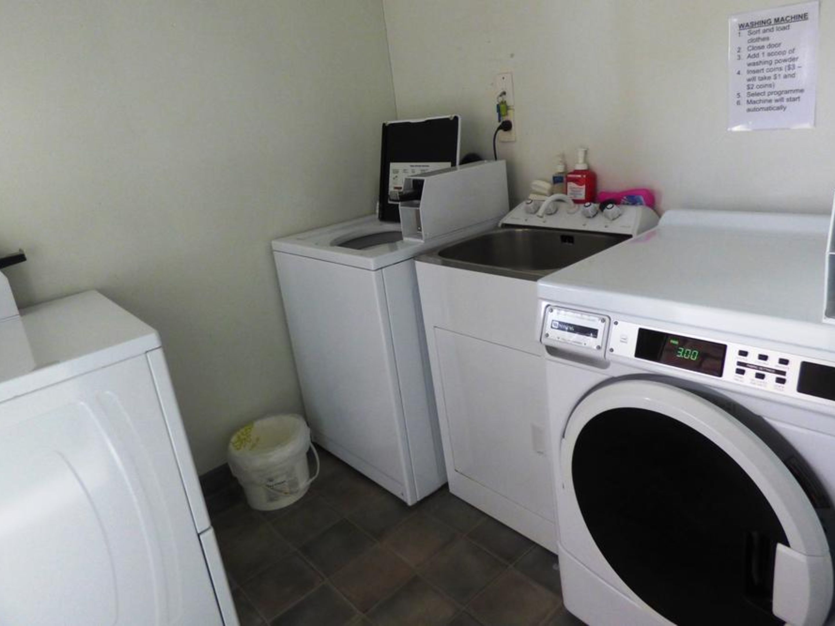 Une buanderie équipée d’un lave-linge, d’un sèche-linge et d’un petit évier.