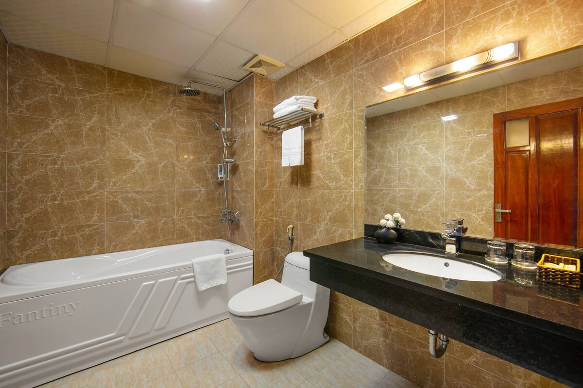 A modern bathroom with a bathtub, toilet, and sink.