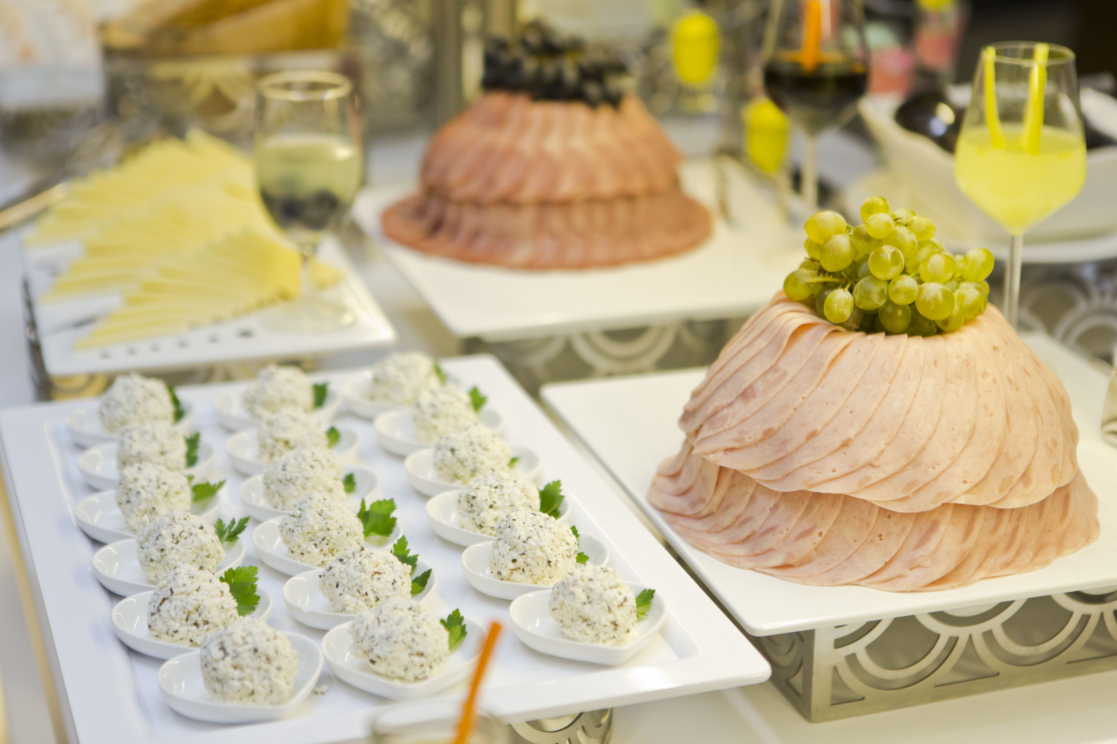 A buffet with various dishes including a large cake with grapes on top, and several small plates of food.