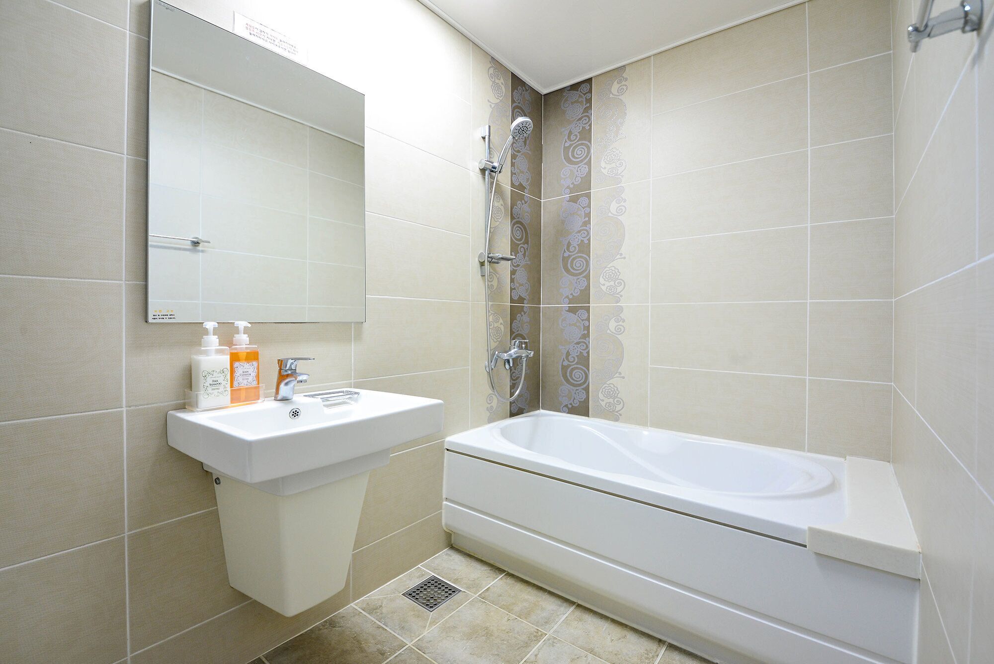Une salle de bain avec un lavabo, un miroir et une baignoire.