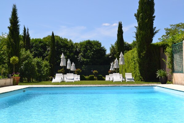 En säsongsöppen utomhuspool och parasoller