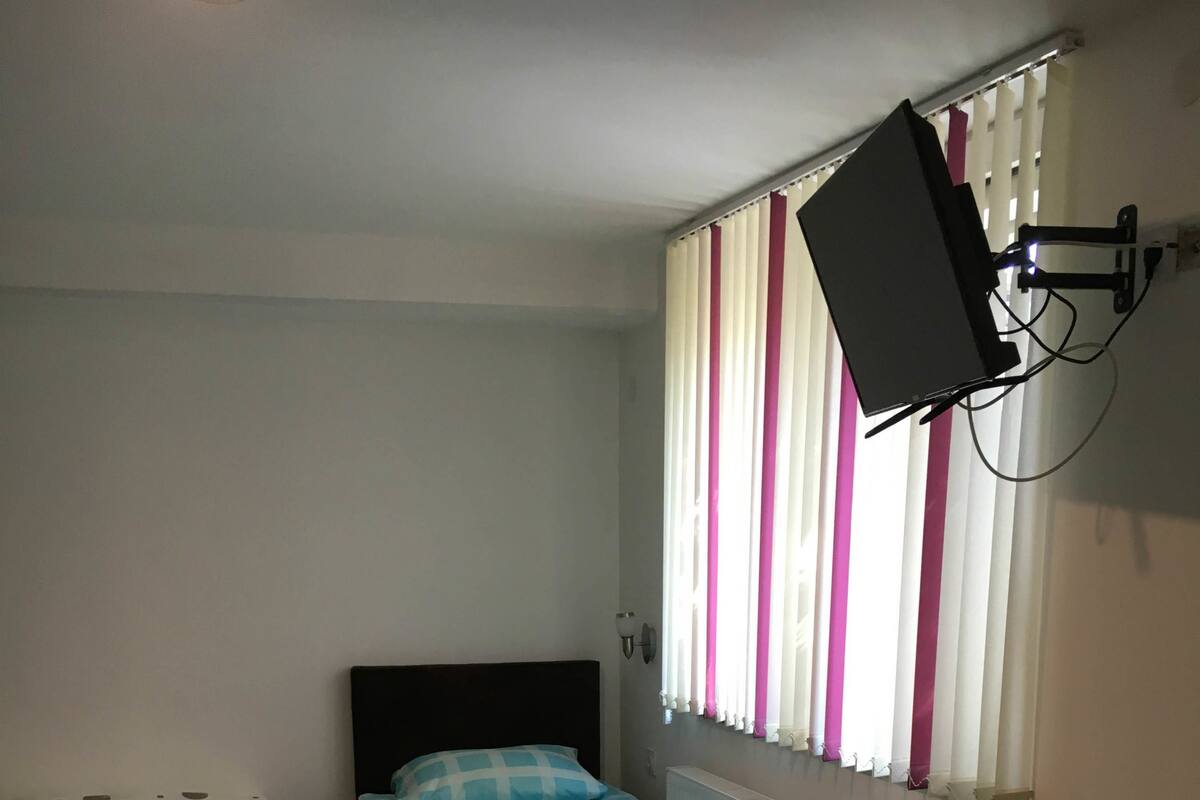 Una habitación pequeña y funcional con dos camas individuales, un escritorio y una silla.