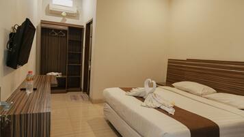 Habitación de hotel con cama, escritorio, espejo y armario.